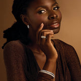 Woman wearing diamond earrings against a brown background