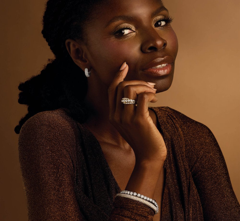 Woman wearing diamond earrings against a brown background
