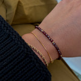 Close-up of a wrist wearing two bracelets on a blurred background