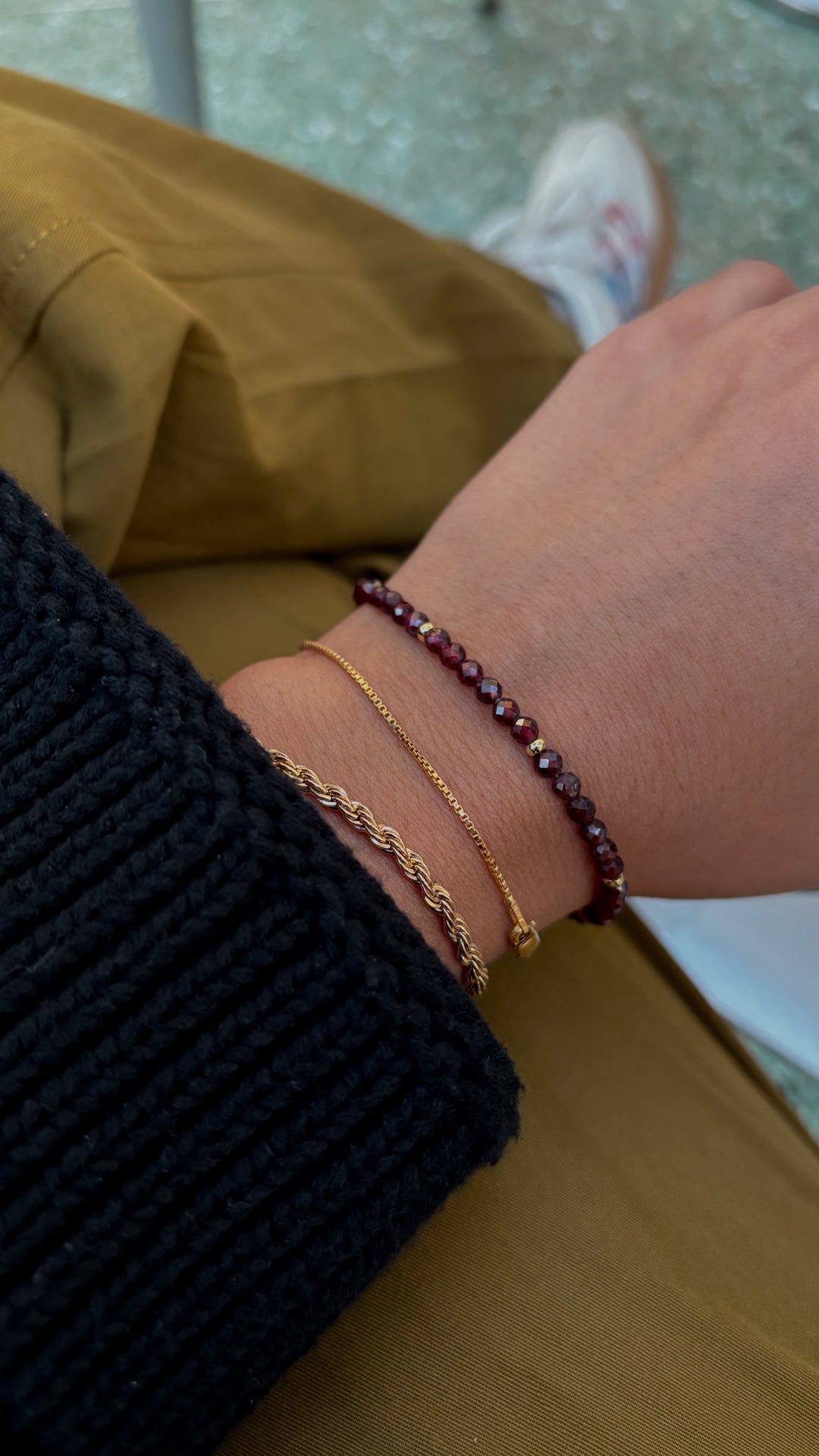 Close-up of a wrist wearing two bracelets on a blurred background
